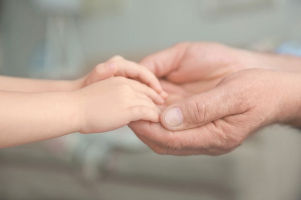 adult holding child's hands